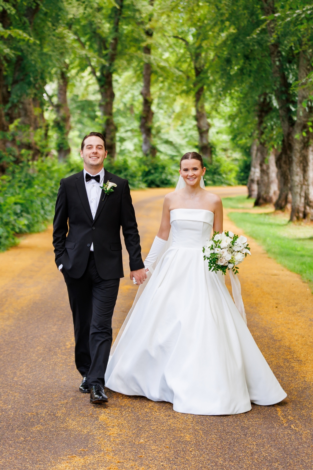 Newlyweds walking along a wooded path