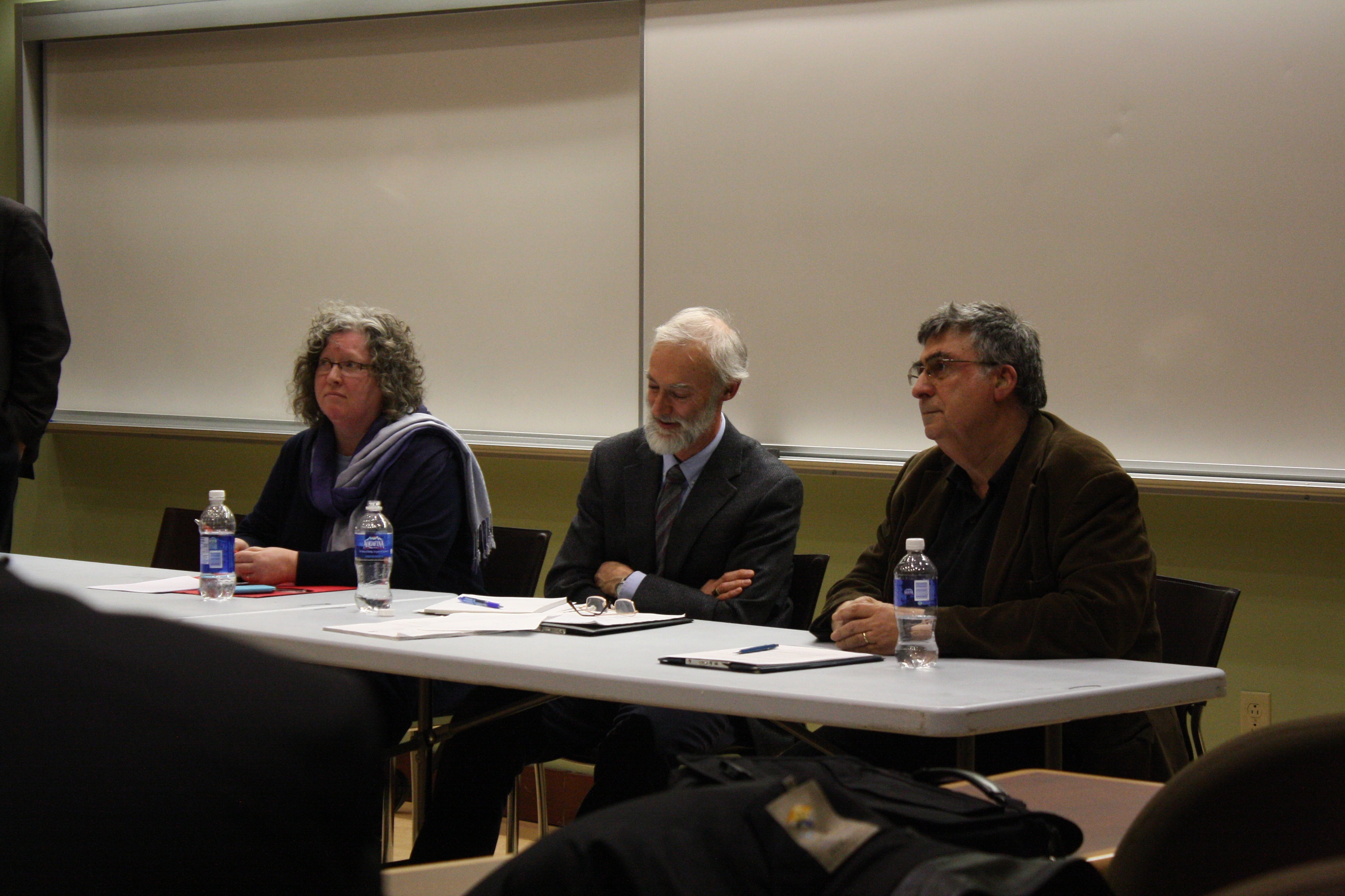 In the picture, 3 Professors sit in a table while on a Q&A session