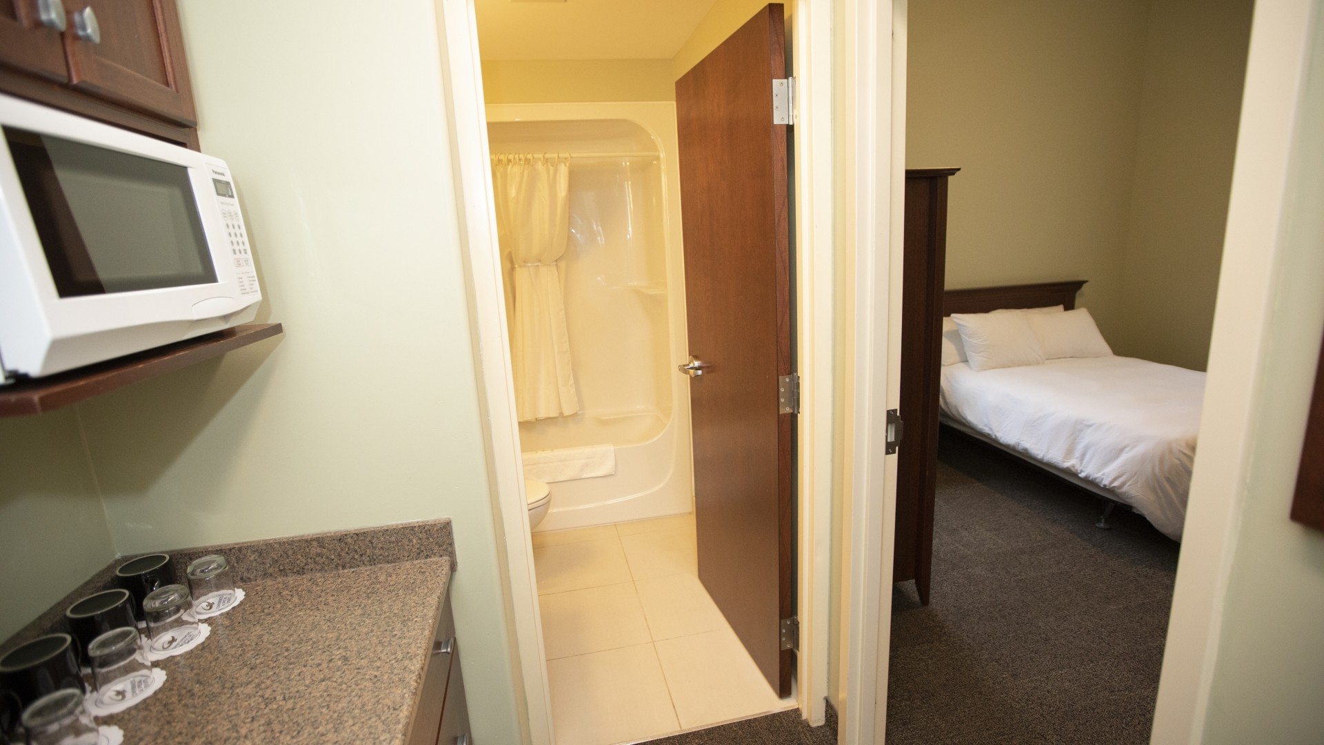 Governors Hall double suite with a bathroom, microwave and one of the two double beds.  