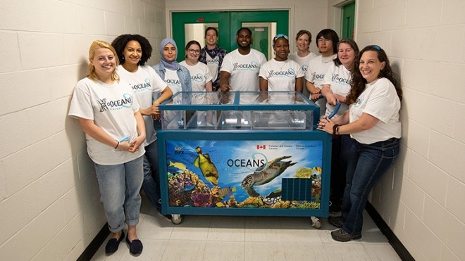 Members of X-Oceans around a touch-tank