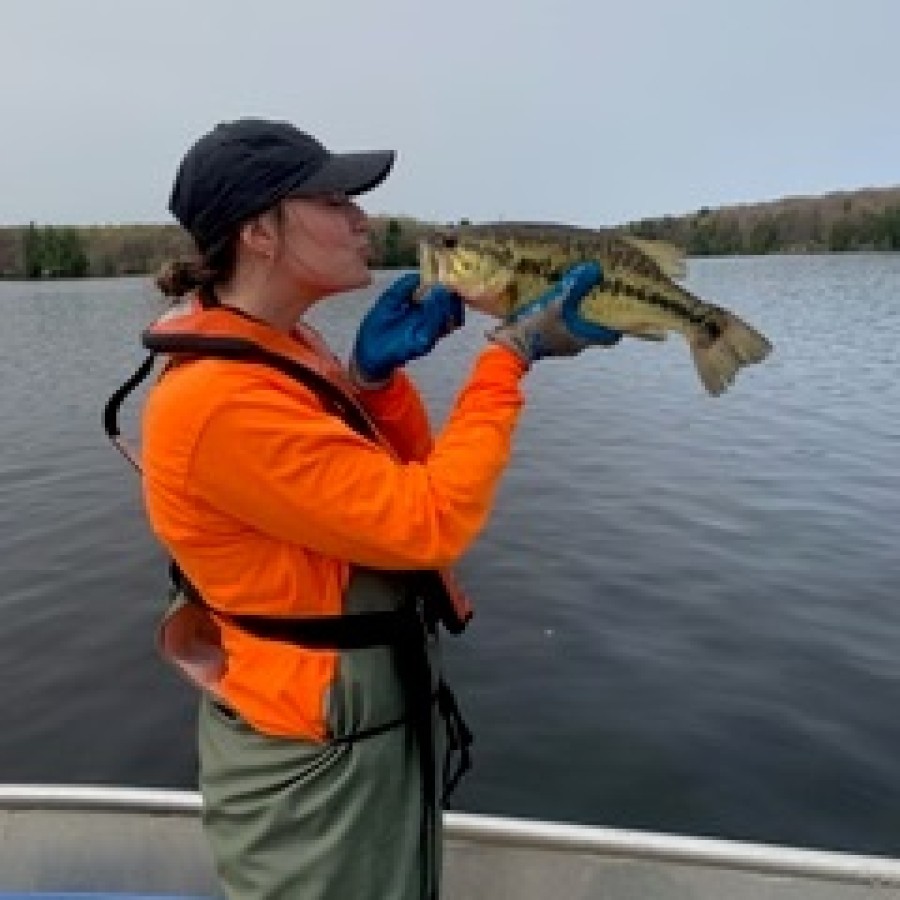 Person holding a fish on a boat