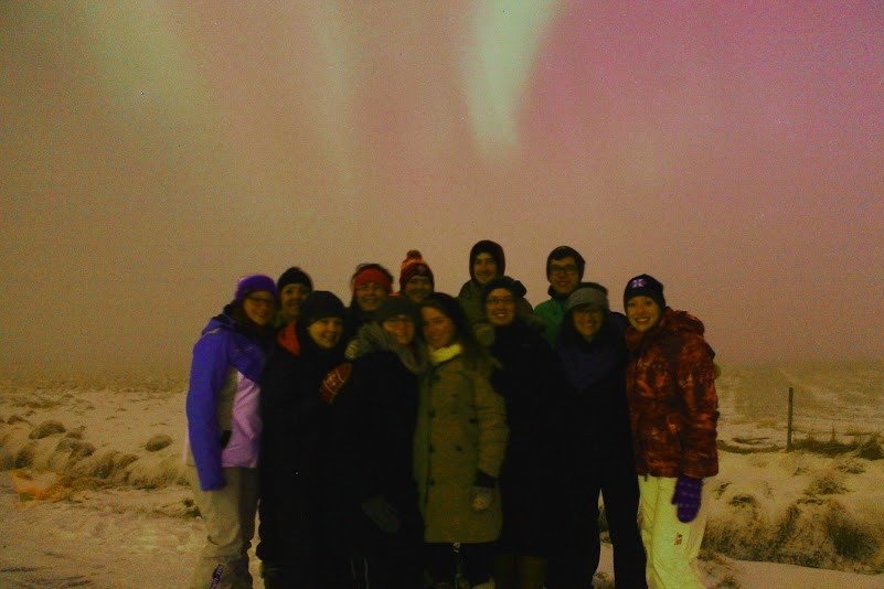 A group of people standing on top of a snow covered slope