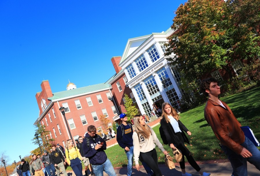 Students walking outside on a sunny day, leaving the Gerald Schwartz School of Business.