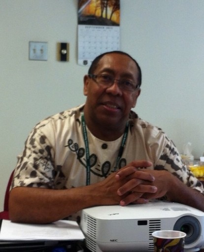 Portrait of person sitting down at table and smiling