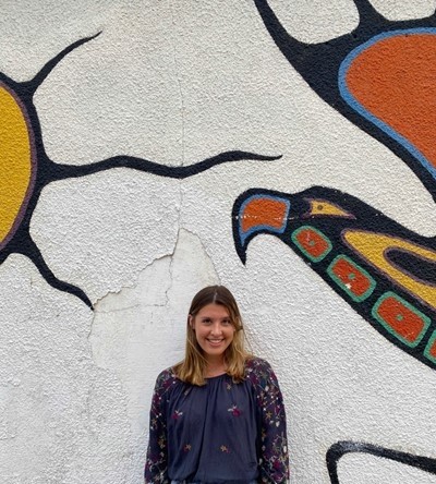 Person standing in front of a mural